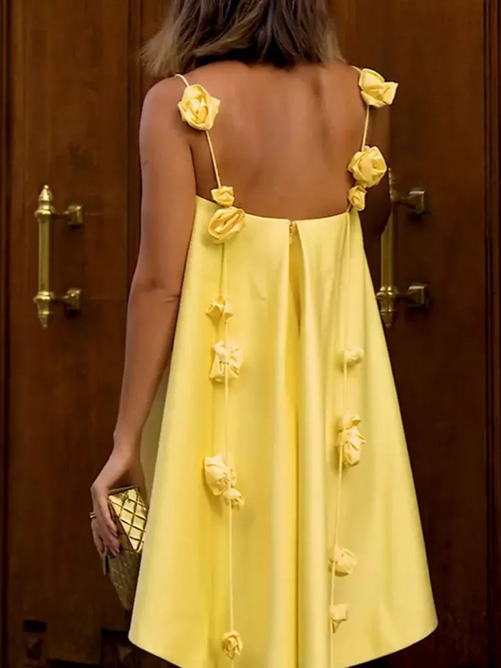 Yellow A-line mini dress with floral applique straps and hanging floral details.