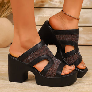 Black open-toe block heel sandals with cut-out details and a textured glitter fabric band.
