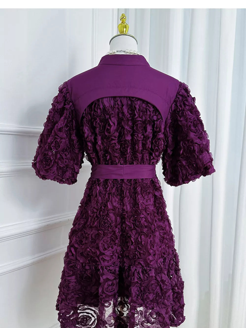 Purple floral textured puff sleeve dress with button detail and belted waist.