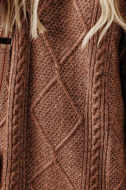 Brown cable knit sweater dress with diamond pattern and braided details.