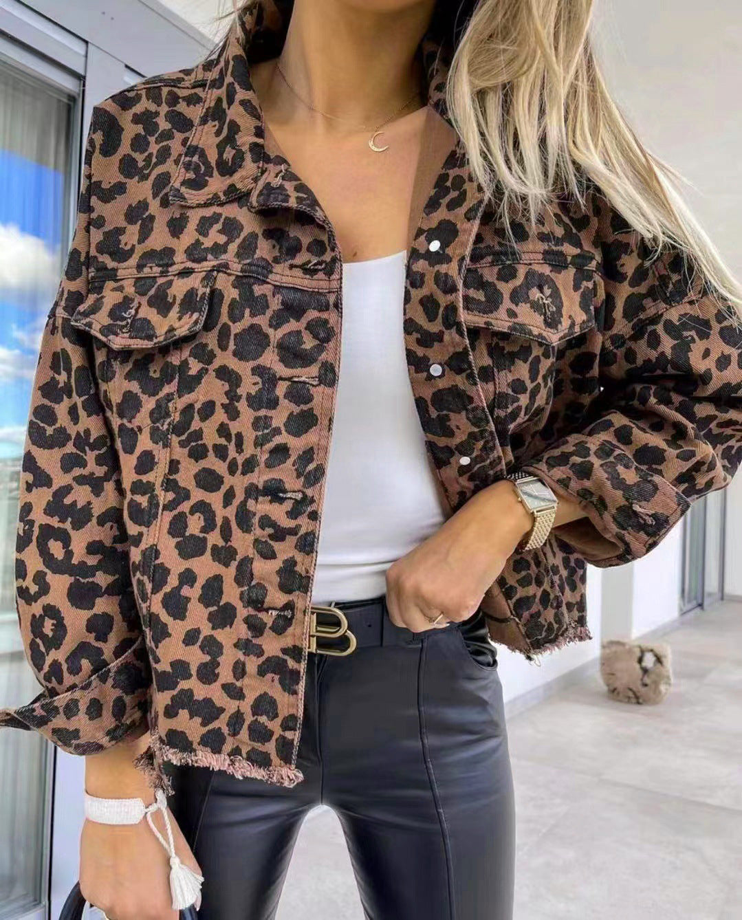 Leopard print denim shacket with raw hem and buttoned pockets.