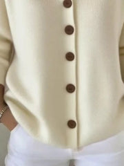 Cream knit cardigan with brown buttons, casual button-front style.