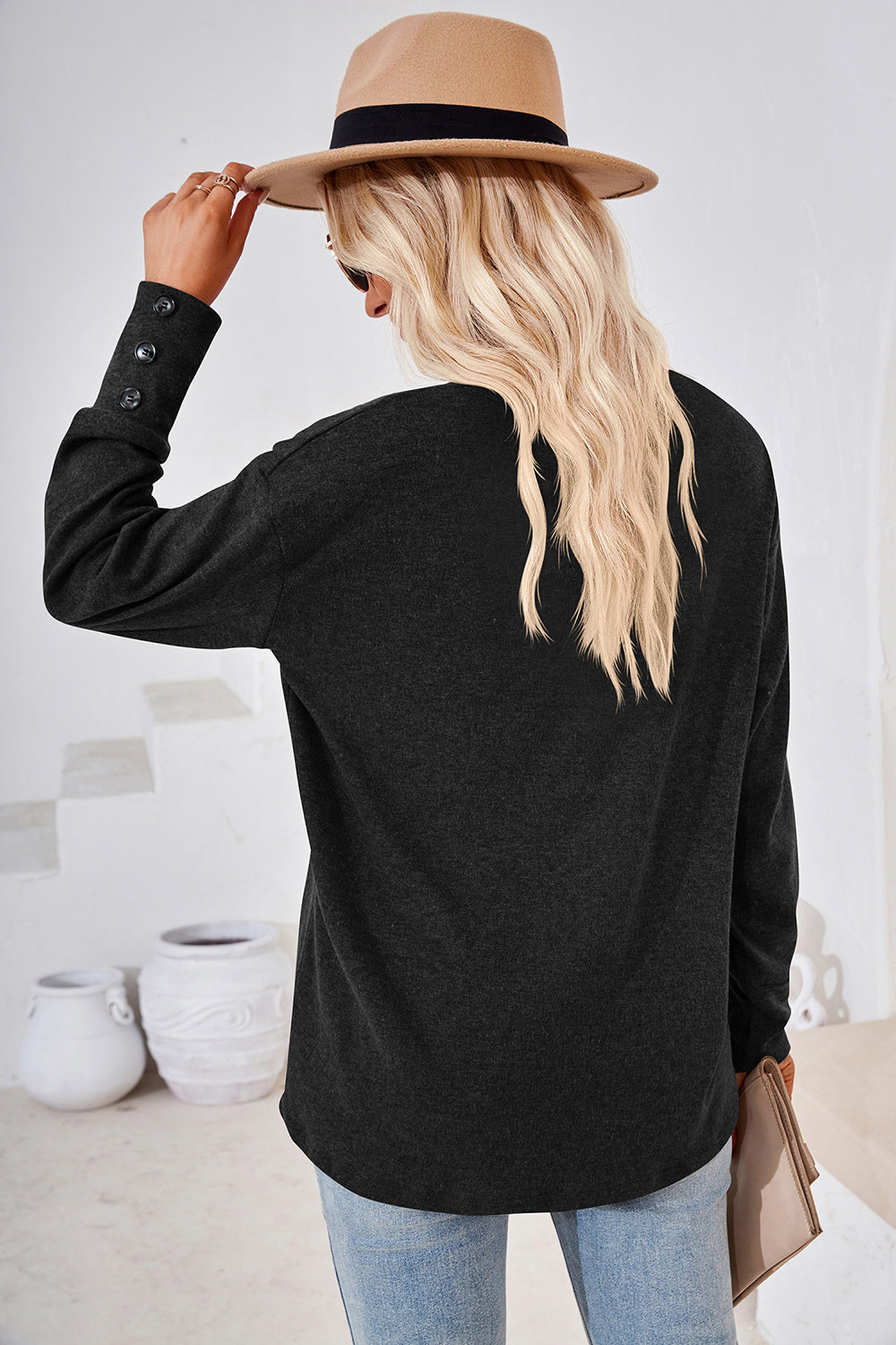 Black slouch v-neck top with button cuffs and a relaxed fit.