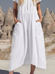 White midi dress with zip neckline, elastic waist, and large functional pockets.