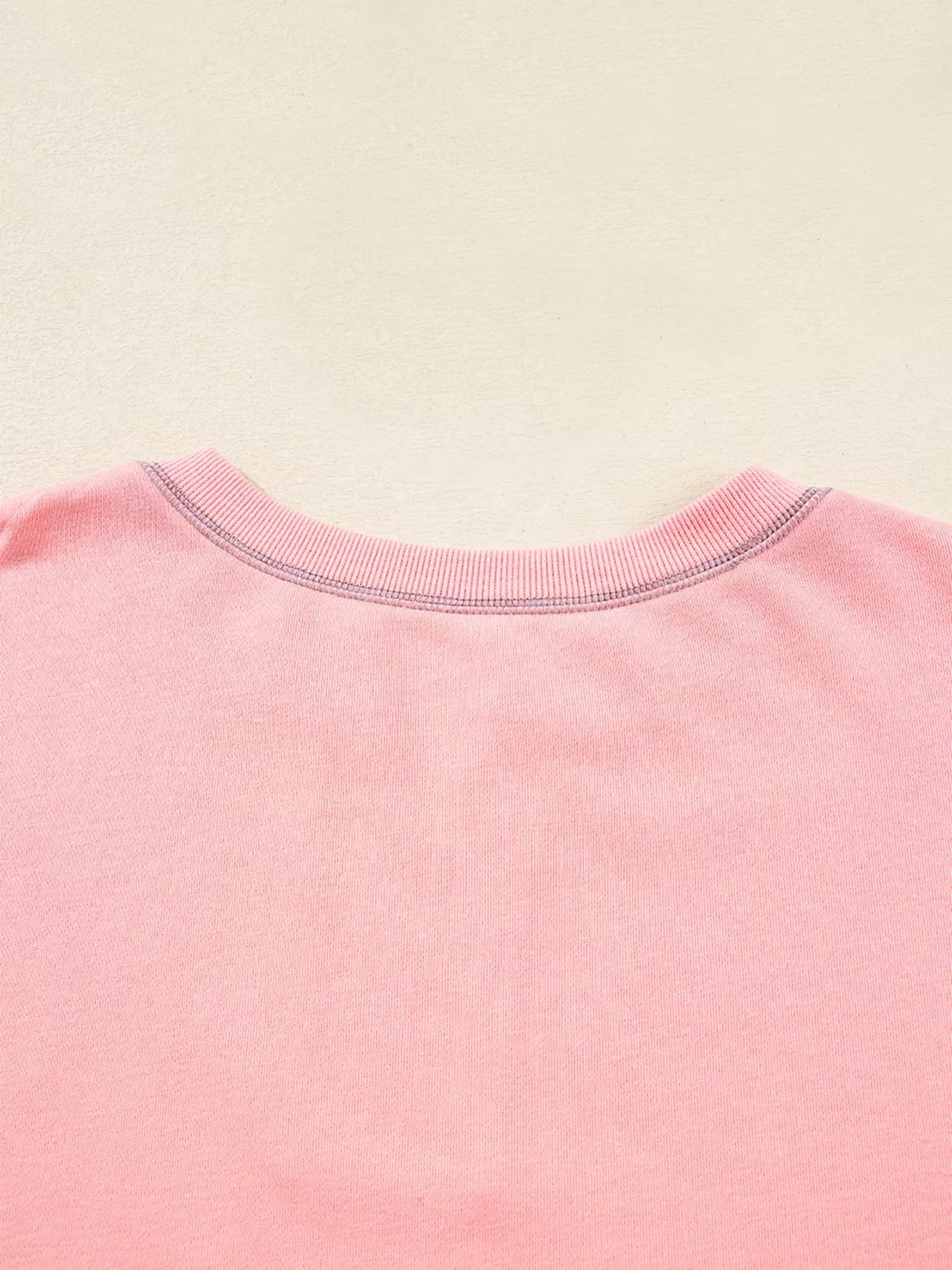 Dusty pink oversized sweatshirt with contrast stitching detail at the neckline.