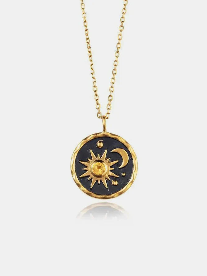 Gold celestial medallion pendant necklace with sun, moon, and zircon detail on a fine chain.