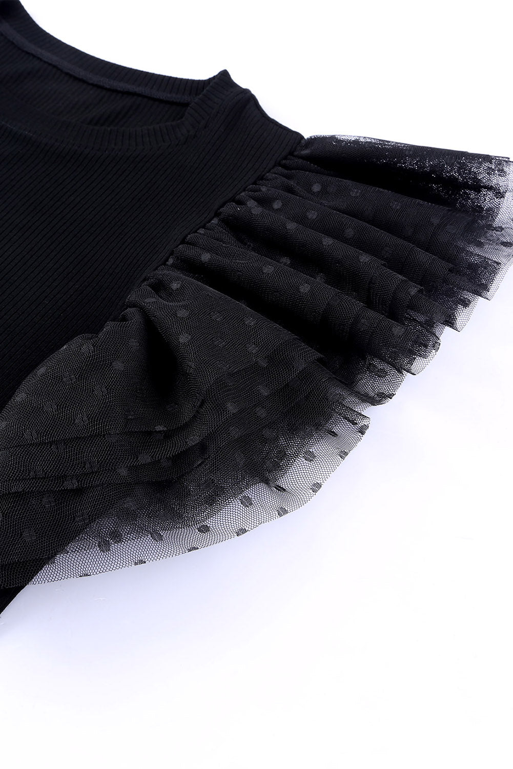 Black ribbed knit blouse with ruffled dot mesh sleeves.