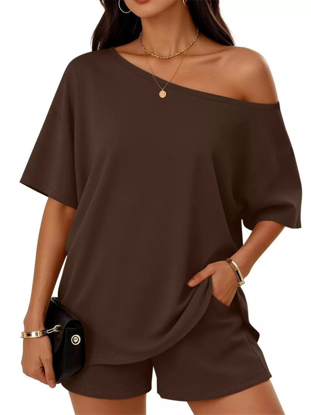 Asymmetrical one-shoulder set in dark brown with pockets, short sleeves, and shorts.