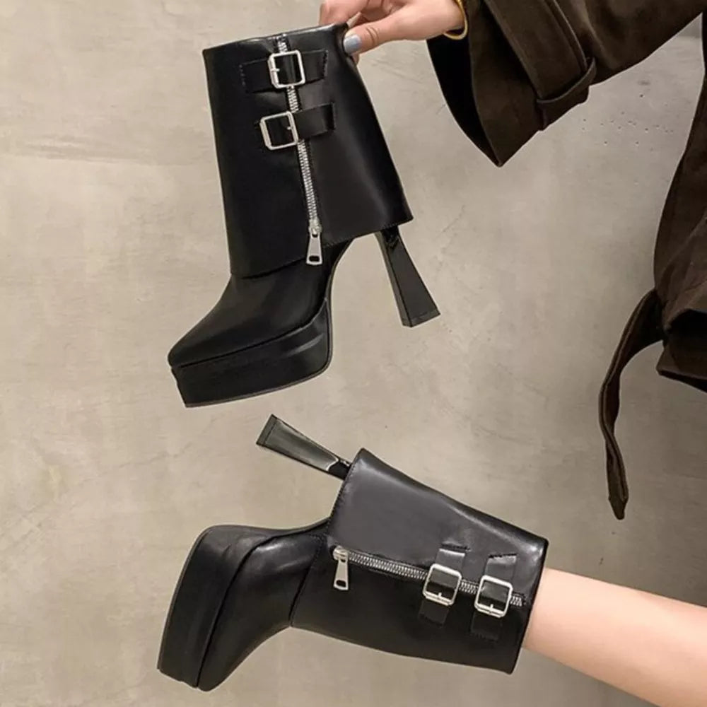 Black ankle boots with pointed toe, platform, block heel, zipper and buckle straps.