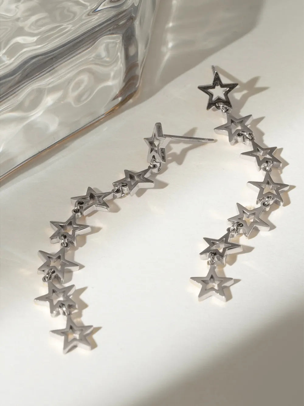 Silver celestial star dangle earrings with multiple stars cascading down.