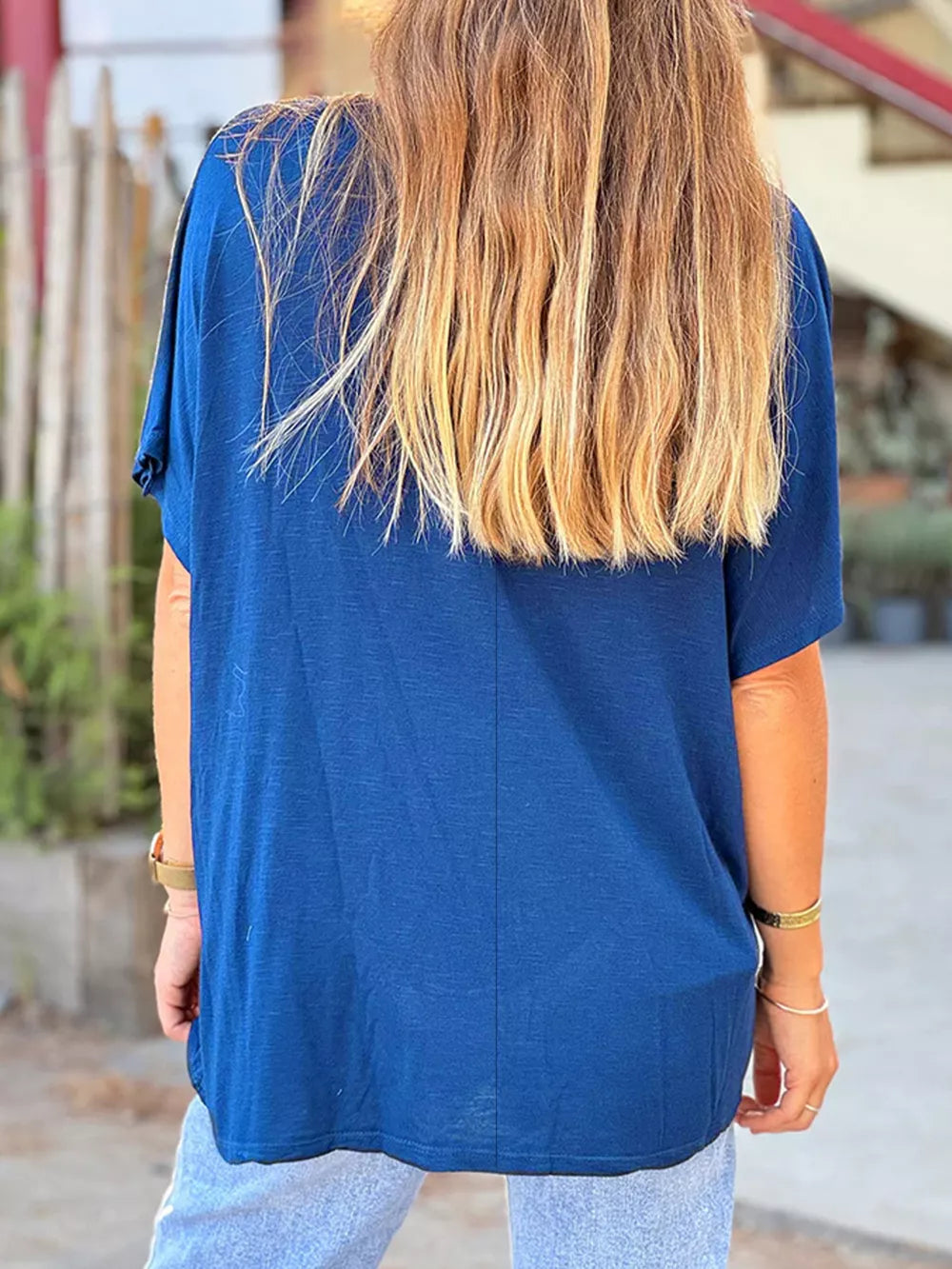 Blue polyester relaxed fit tee with short sleeves and a V-neck, shown from the back.