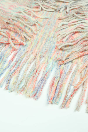 Textured knit cape detail with colorful fringe and a woven pattern.