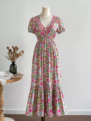 Maxi dress with V-neck, short puff sleeves, floral print, and decorative trim.