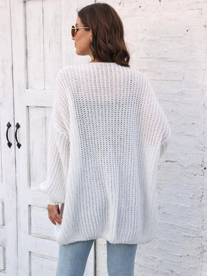 White balloon sleeve knit cardigan with pearl buttons, styled with jeans.