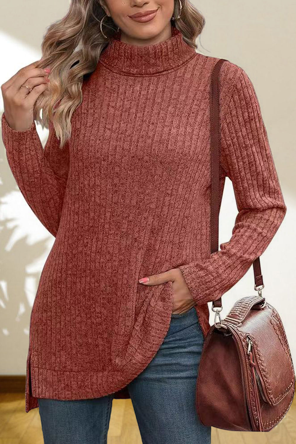 Ribbed knit turtleneck tunic top in red orange with side slits and a relaxed fit.