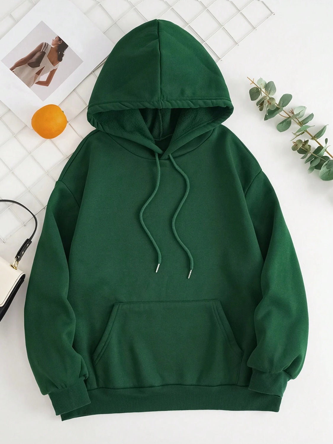 Dark green oversized hoodie with pouch pocket and drawstring hood.