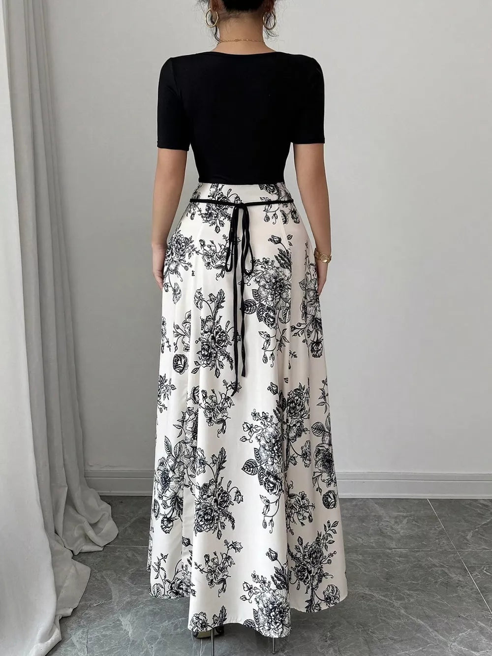 Maxi dress with black floral print, square neckline, and tie waist.