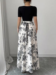 Maxi dress with black floral print, square neckline, and tie waist.