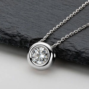 Silver solitaire pendant necklace with bezel-set clear stone on a delicate chain.