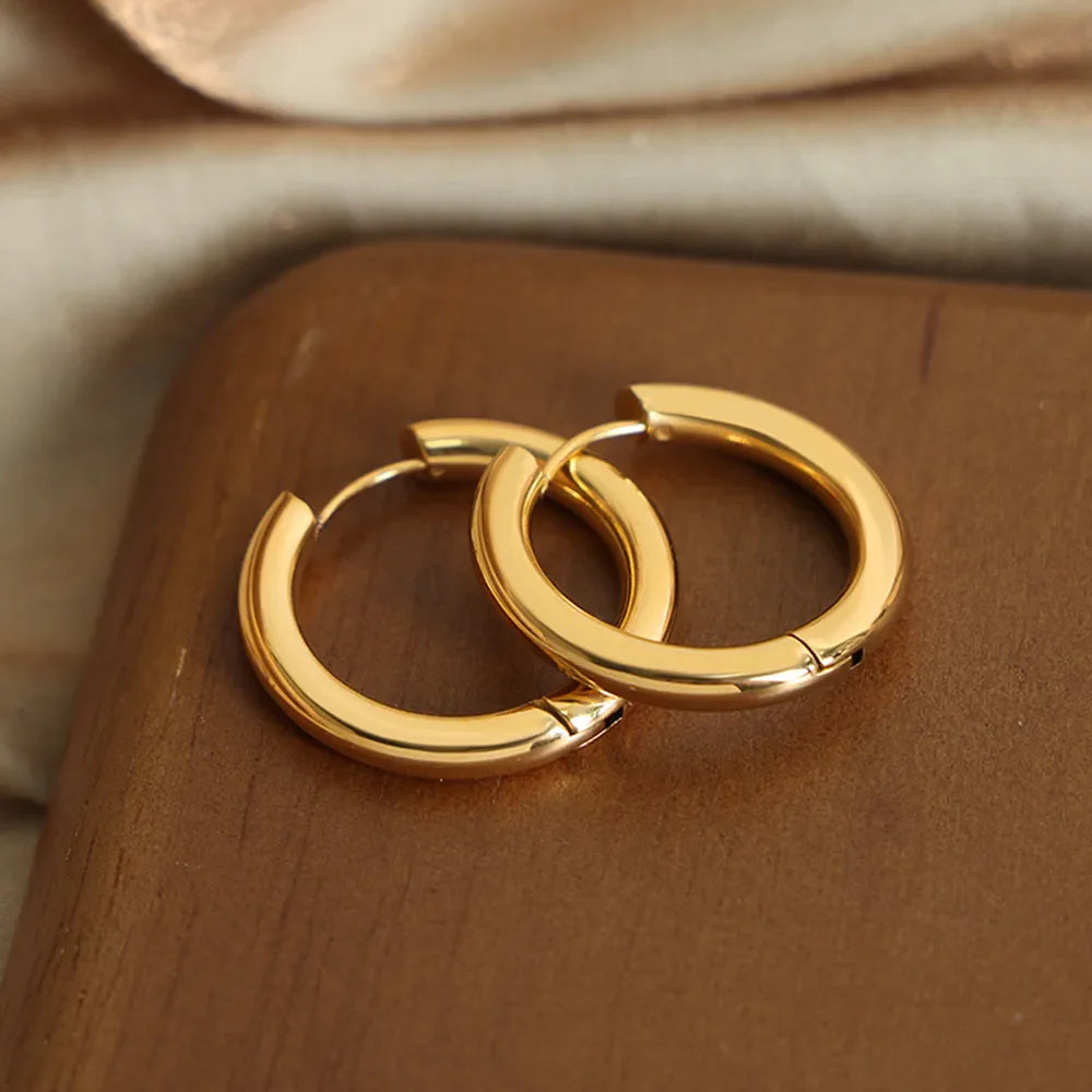 Gold hoop earrings with a sculpted design and 18K gold plating.