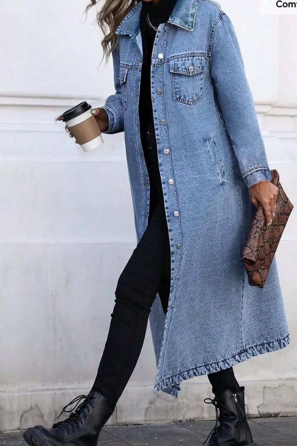 Longline blue denim jacket with pockets and button front, worn open over black pants.