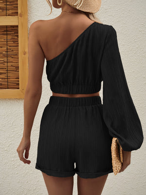 Black textured one-shoulder crop top and cuffed shorts set with one long balloon sleeve.