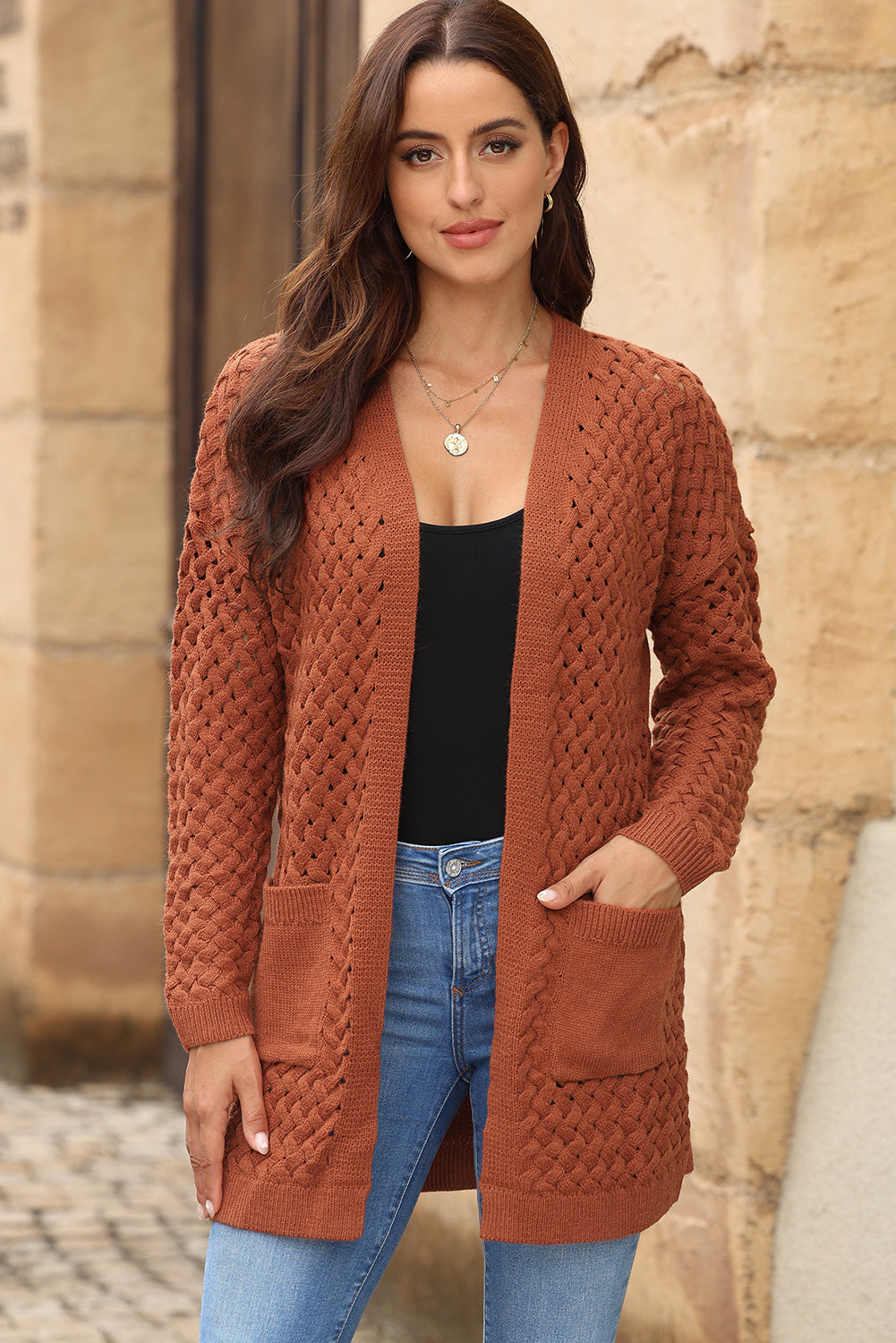 Textured open-knit pocket cardigan in caramel acrylic with open front and long sleeves.