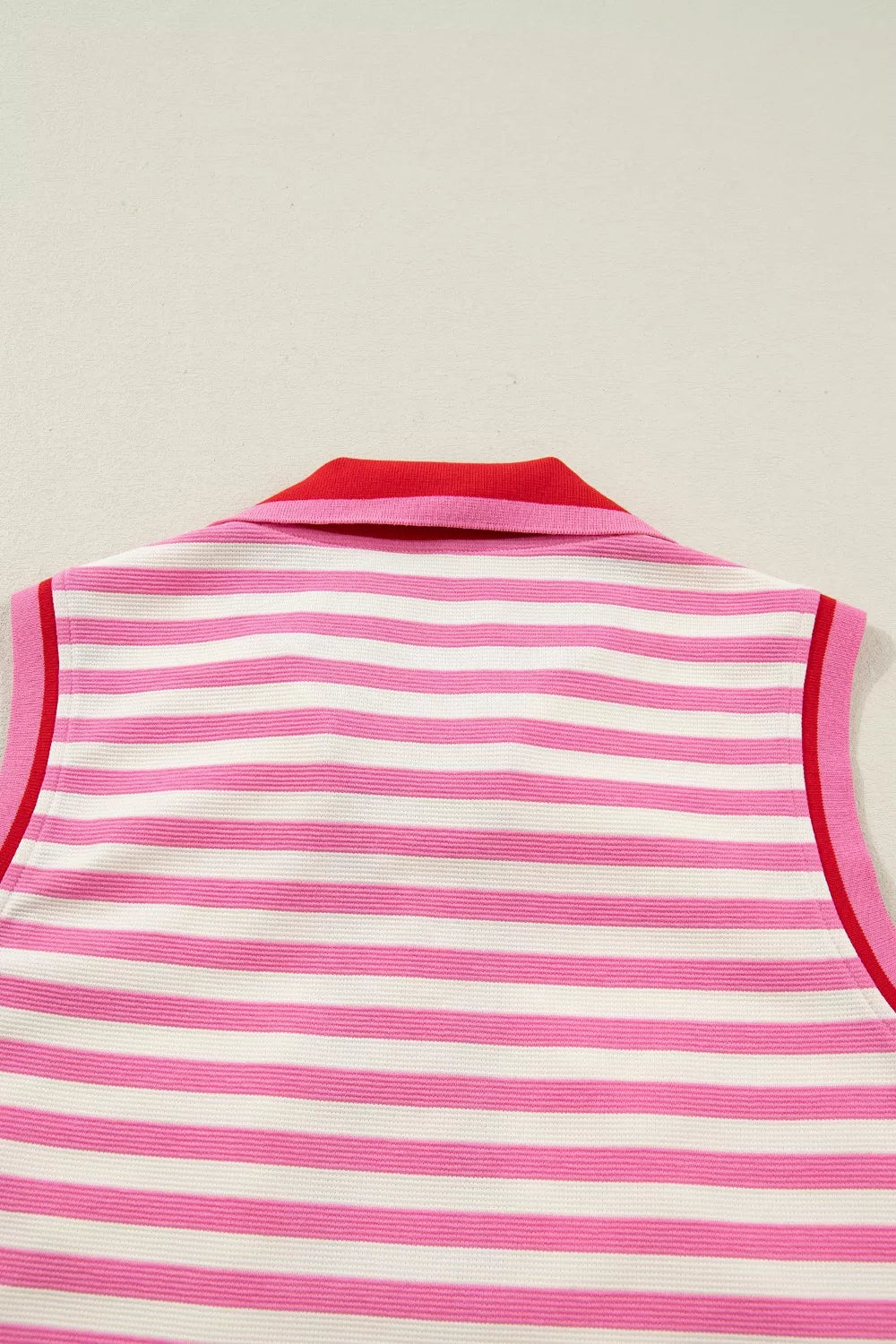 Pink and white striped polo top with red collar and trim