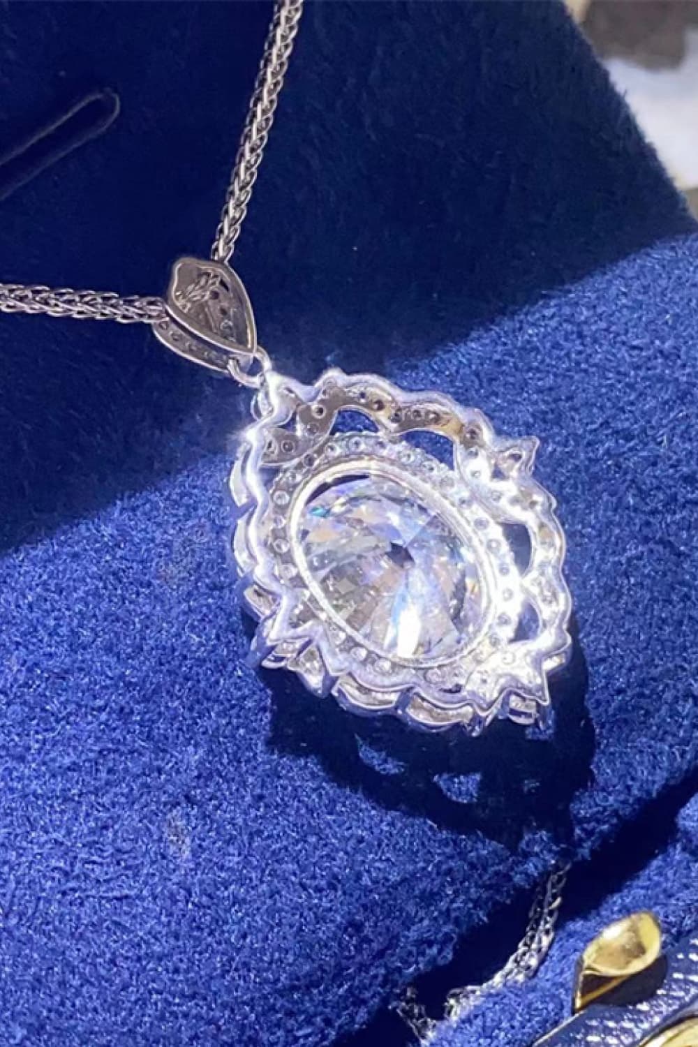 Silver filigree halo pendant necklace with oval diamond and chain.
