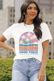 White graphic t-shirt with a retro sunset and palm trees design and "Good Times and tan lines" text.