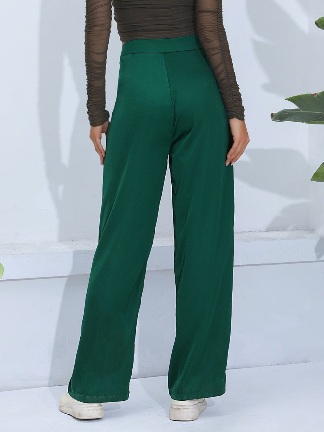 Dark green wide-leg trousers with button detail, shown from the back.