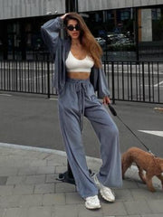Plush velour lounge set in charcoal, featuring wide leg pants with drawstring and matching zip-up jacket.