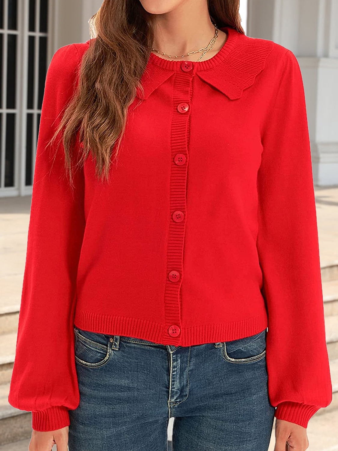 Red knit cardigan with scalloped collar, button front, and balloon sleeves.