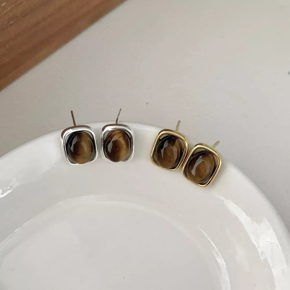 Polished tiger eye square stud earrings in gold color and silver settings.