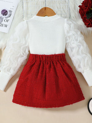 Children's red tweed skirt with white textured top and sheer ruffled sleeves.