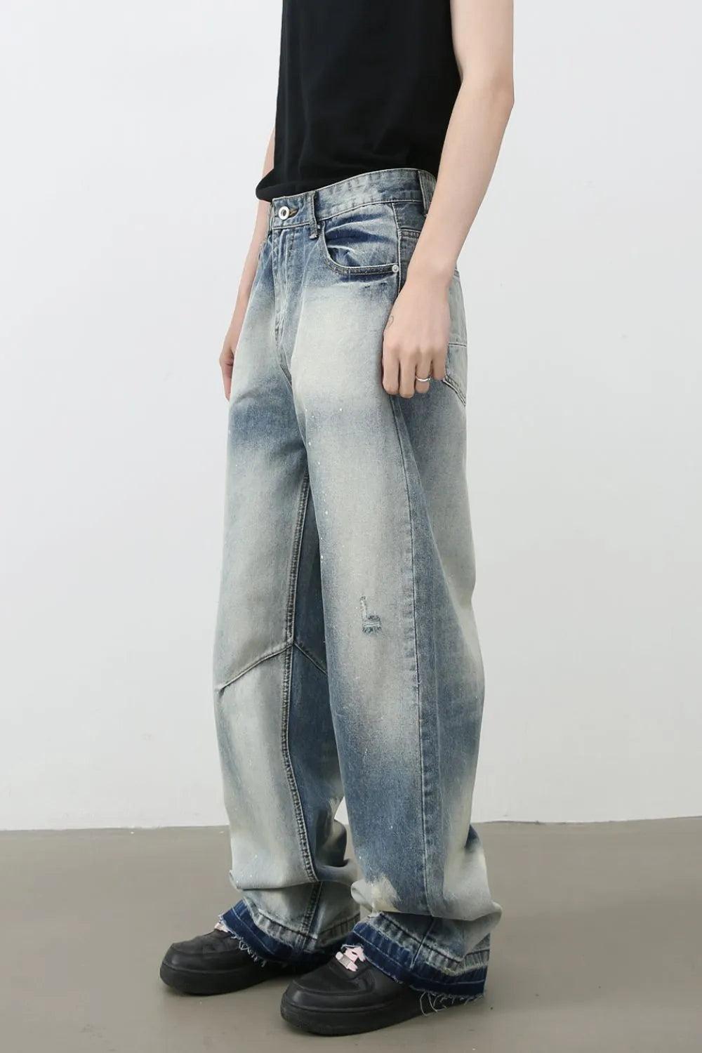 Distressed painterly wide-leg jeans in medium wash denim with paint splatters and ripped details.