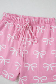 Pink ribbed lounge shorts with white bow print and drawstring waist.