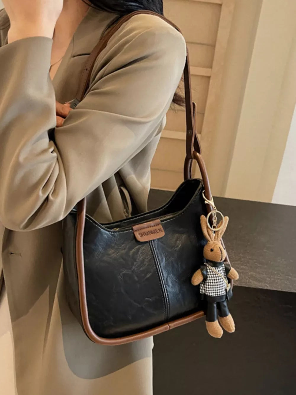 Black pu leather shoulder bag with brown piping and bunny charm