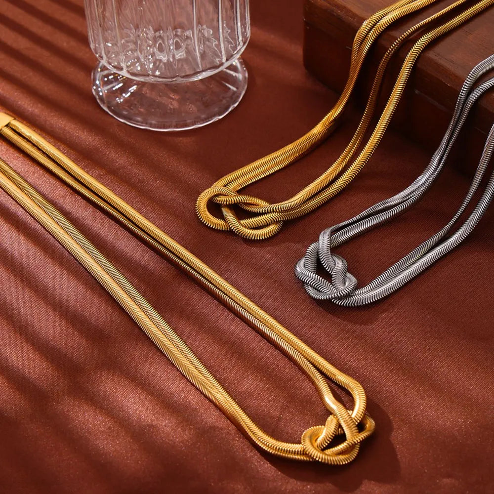 Gold and silver serpent necklaces with knot detail