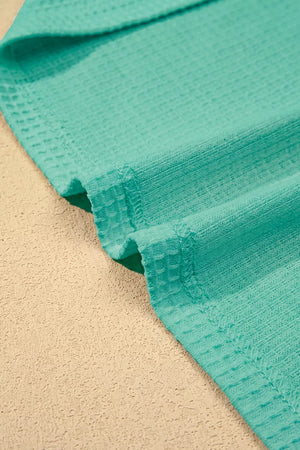 Teal waffle knit shirt with lace trim detail.