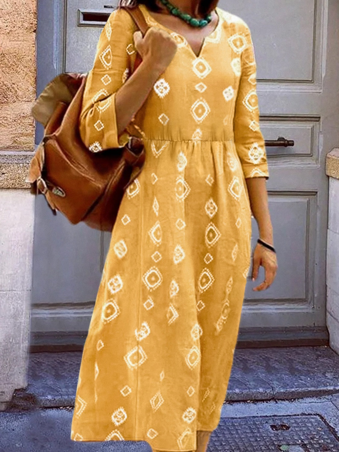 Yellow geometric print empire waist midi dress with 3/4 sleeves and V-neck.