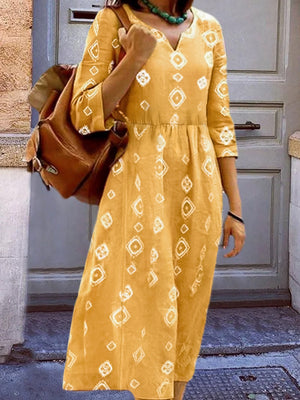 Yellow geometric print empire waist midi dress with 3/4 sleeves and V-neck.