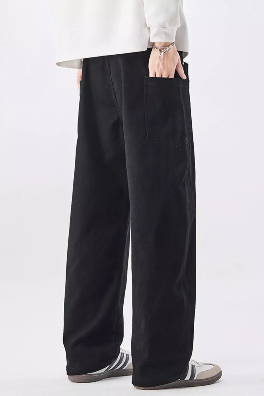 Men's relaxed fit black cotton jeans with drawstring waist and back pocket detail.