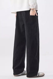 Men's relaxed fit black cotton jeans with drawstring waist and back pocket detail.