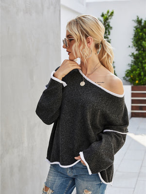 Dark gray off-shoulder knit pullover sweater with white trim and wide sleeves.