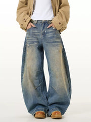 Men's vintage washed oversized wide leg jeans in blue denim with distressed details.