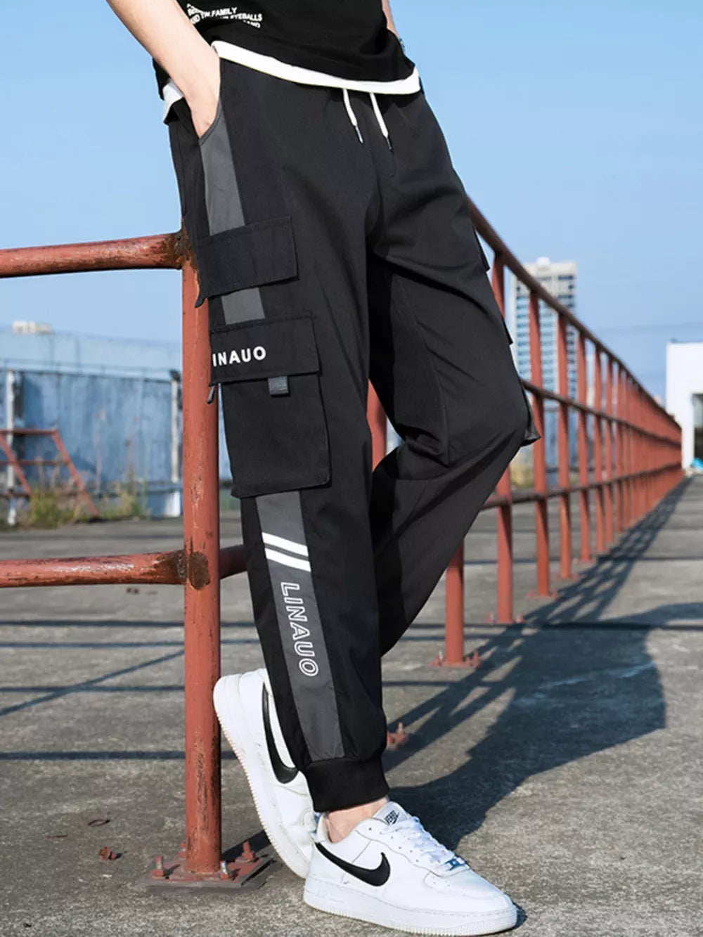 Black cargo joggers with gray accents and white text detail.
