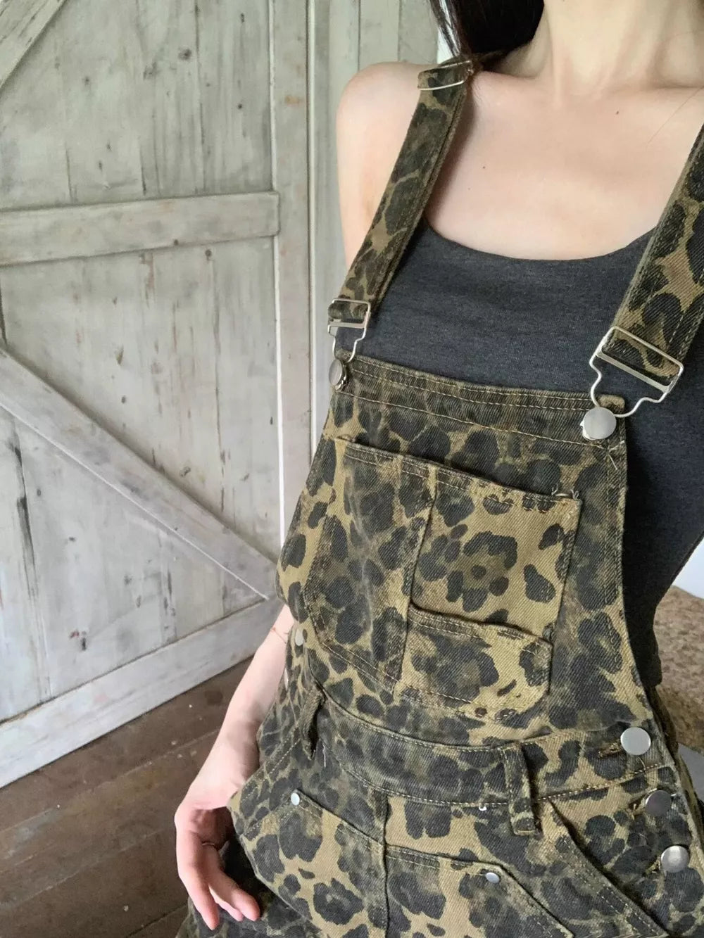 Chic leopard print denim overall dress with adjustable straps and buckle detail.