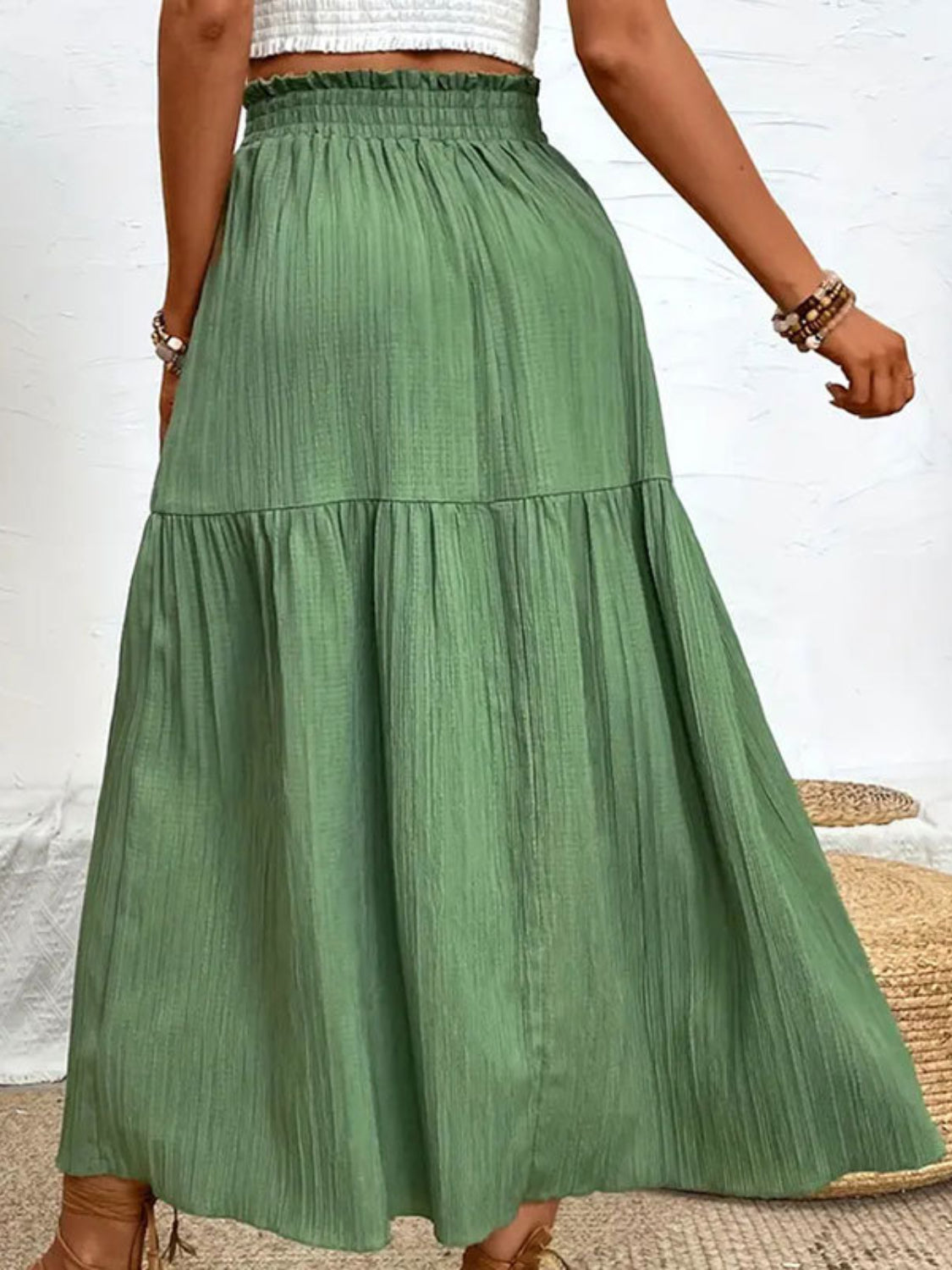 Textured tiered maxi skirt in matcha green with a ruffled waist and subtle vertical texture.