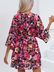 Black floral ruffle hem mini dress with tiered skirt and bell sleeves.